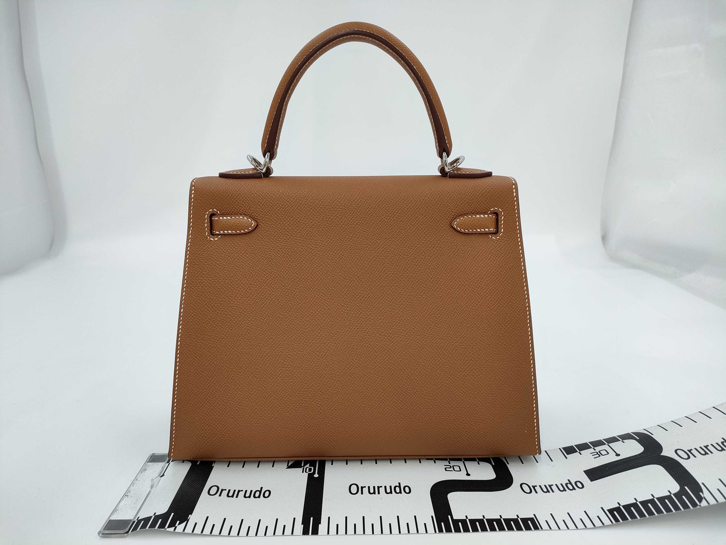 HERMES Kelly 25 handbag with gold exterior, Epsom finish, and silver hardware.