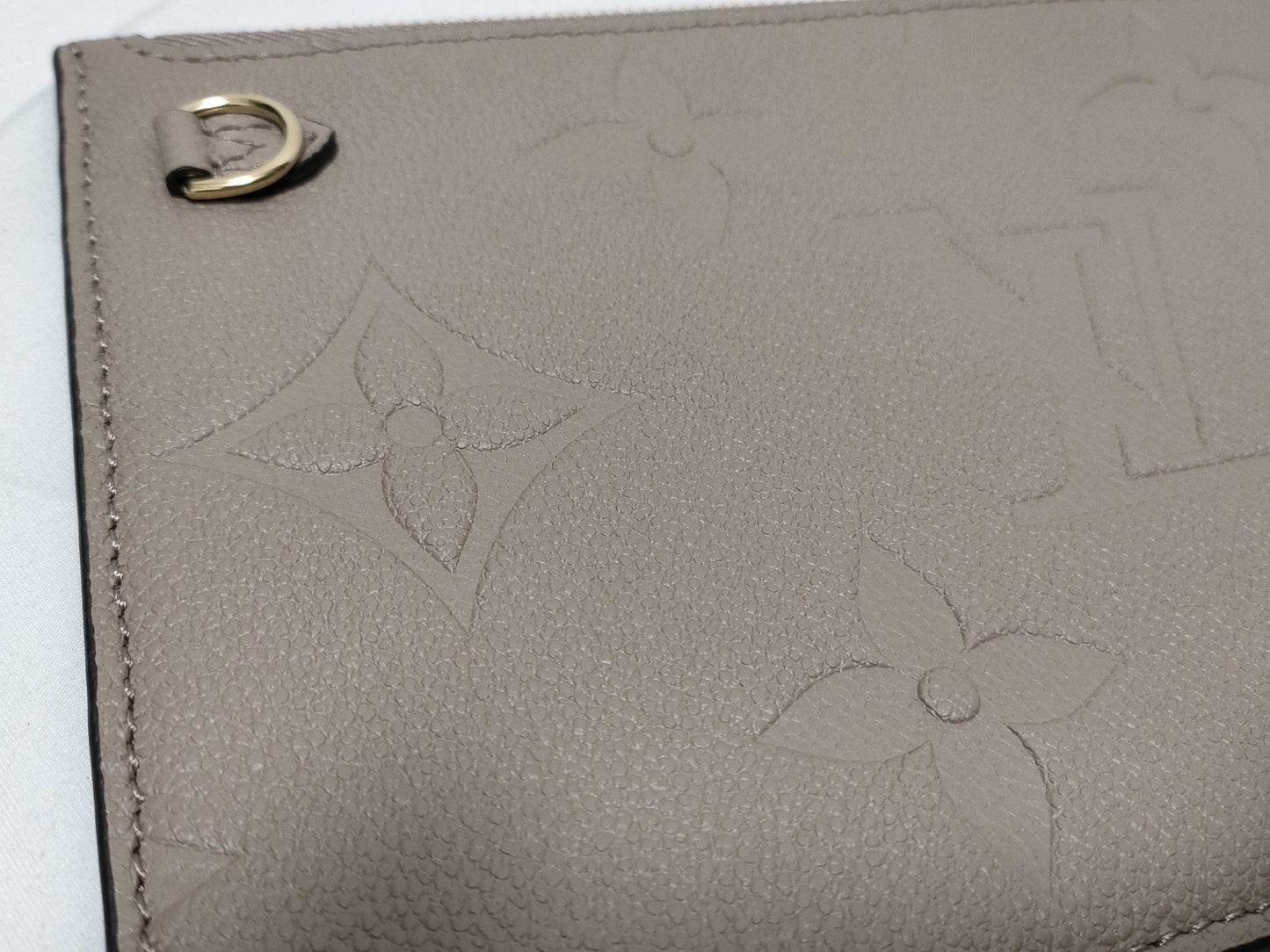 LOUIS VUITTON RFID verification impossible. Serial number verification impossible. Monogram Empreinte Louis Vuitton Neverfull Pouch in Taupe with Gold Hardware.