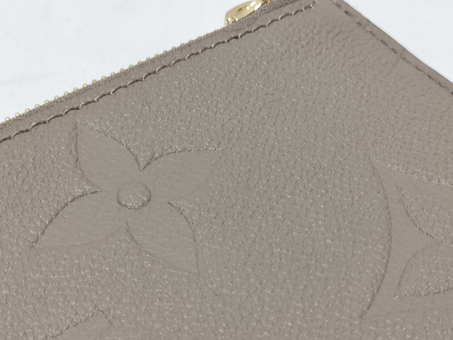 LOUIS VUITTON RFID verification impossible. Serial number verification impossible. Monogram Empreinte Louis Vuitton Neverfull Pouch in Taupe with Gold Hardware.