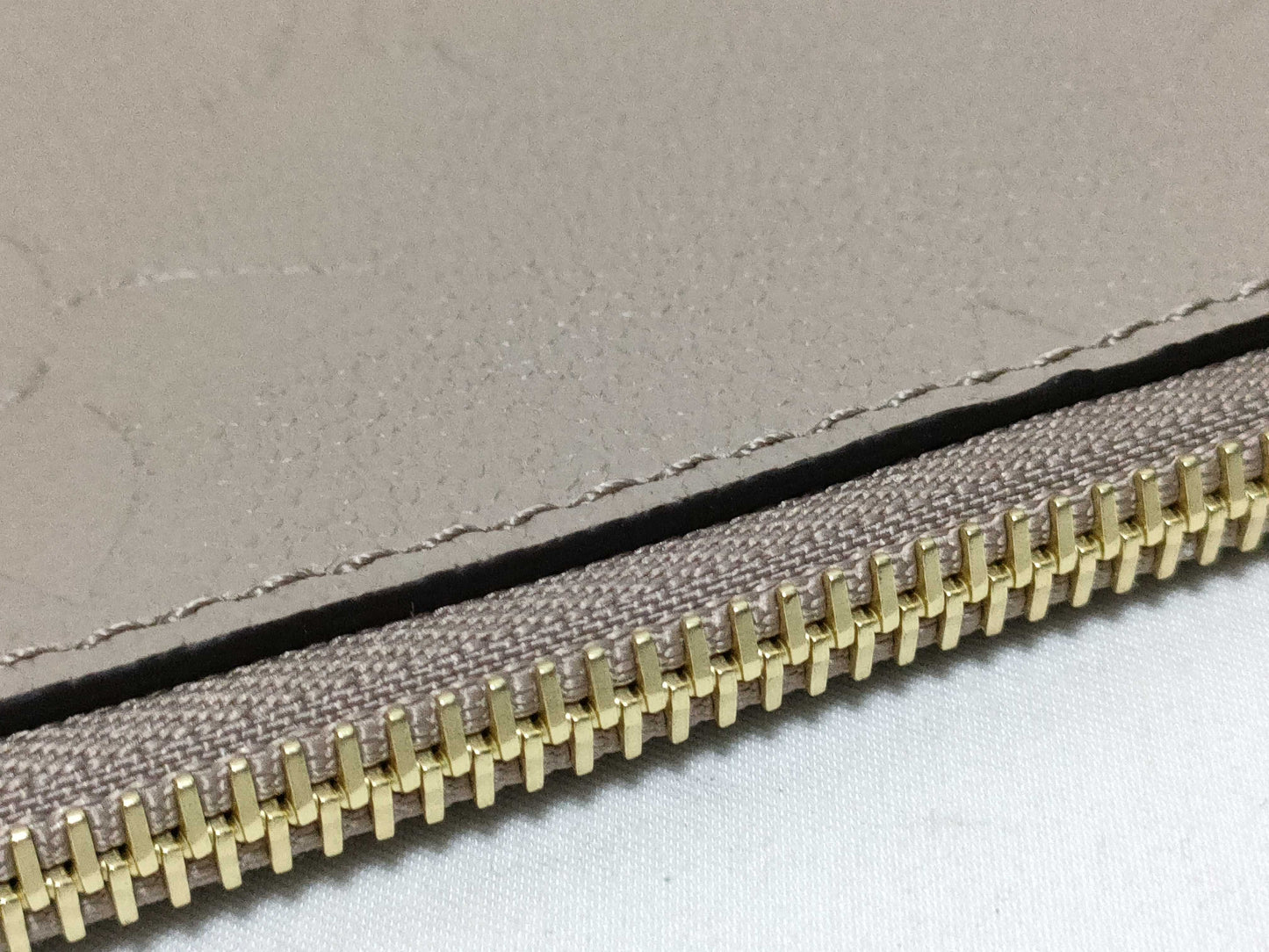 LOUIS VUITTON RFID verification impossible. Serial number verification impossible. Monogram Empreinte Louis Vuitton Neverfull Pouch in Taupe with Gold Hardware.
