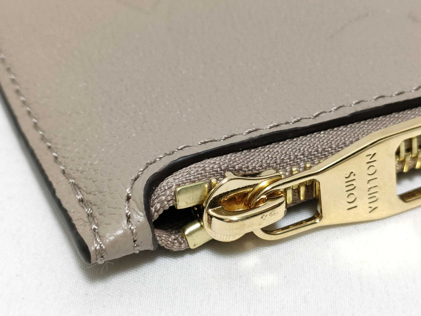 LOUIS VUITTON RFID verification impossible. Serial number verification impossible. Monogram Empreinte Louis Vuitton Neverfull Pouch in Taupe with Gold Hardware.