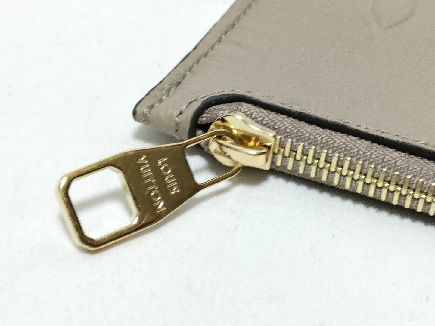 LOUIS VUITTON RFID verification impossible. Serial number verification impossible. Monogram Empreinte Louis Vuitton Neverfull Pouch in Taupe with Gold Hardware.