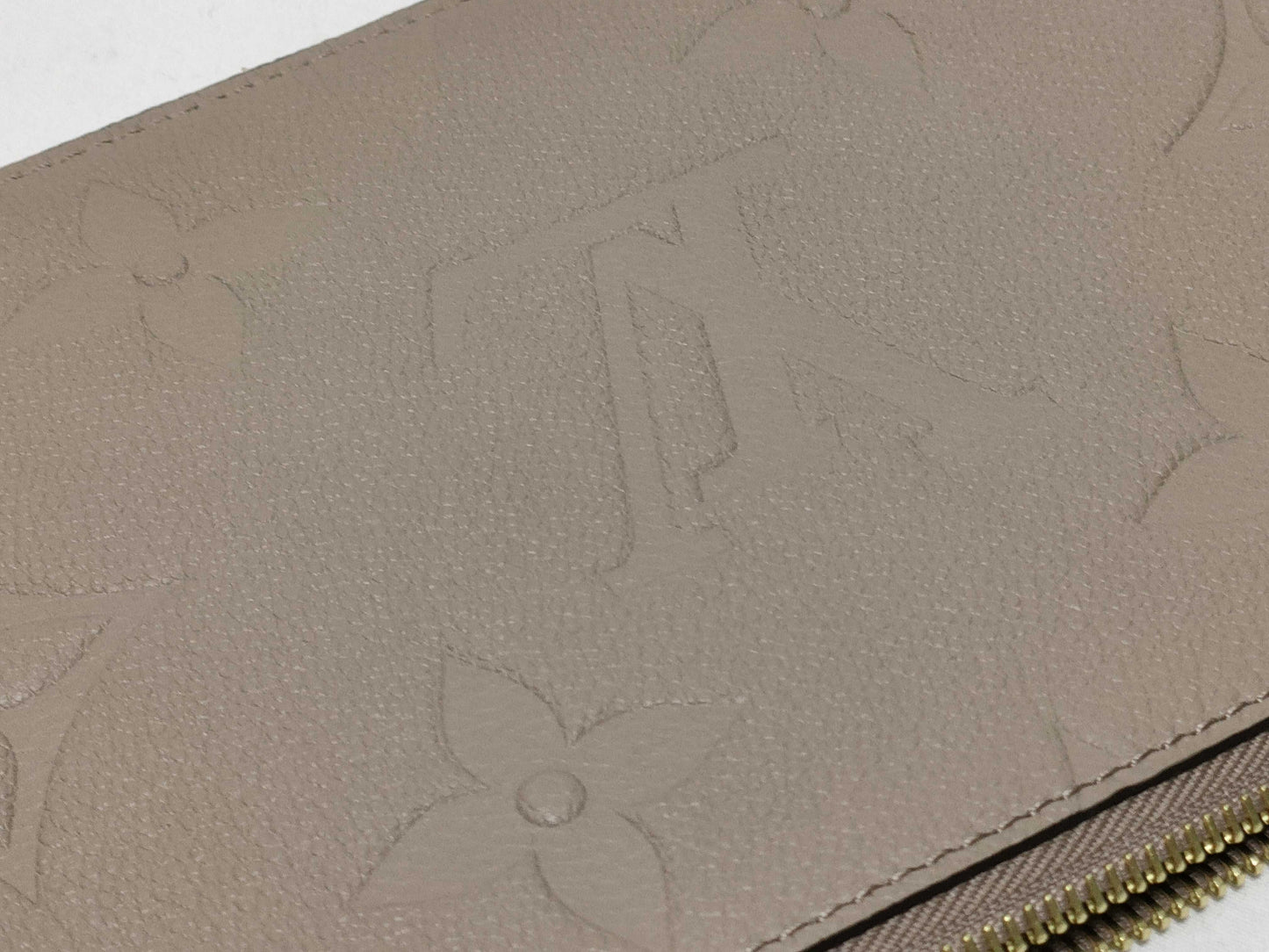 LOUIS VUITTON RFID verification impossible. Serial number verification impossible. Monogram Empreinte Louis Vuitton Neverfull Pouch in Taupe with Gold Hardware.