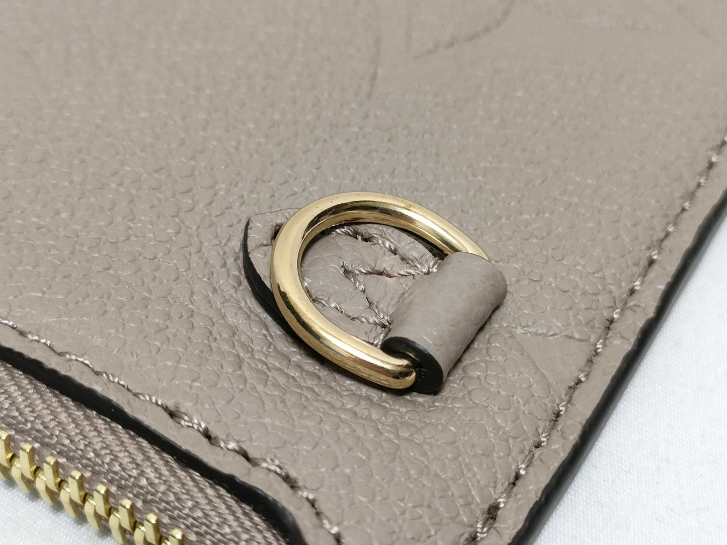 LOUIS VUITTON RFID verification impossible. Serial number verification impossible. Monogram Empreinte Louis Vuitton Neverfull Pouch in Taupe with Gold Hardware.