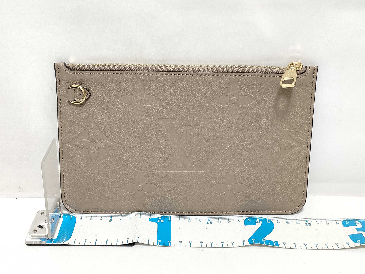 LOUIS VUITTON RFID verification impossible. Serial number verification impossible. Monogram Empreinte Louis Vuitton Neverfull Pouch in Taupe with Gold Hardware.