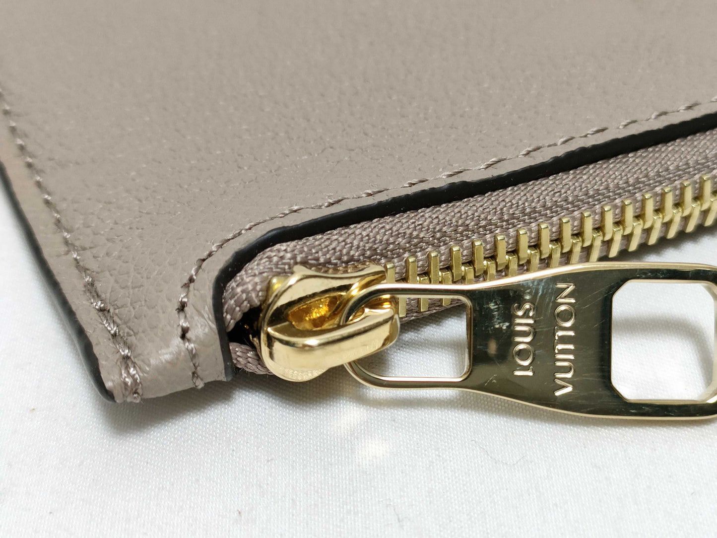 LOUIS VUITTON RFID verification impossible. Serial number verification impossible. Monogram Empreinte Louis Vuitton Neverfull Pouch in Taupe with Gold Hardware.