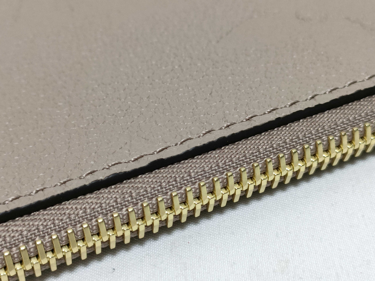 LOUIS VUITTON RFID verification impossible. Serial number verification impossible. Monogram Empreinte Louis Vuitton Neverfull Pouch in Taupe with Gold Hardware.