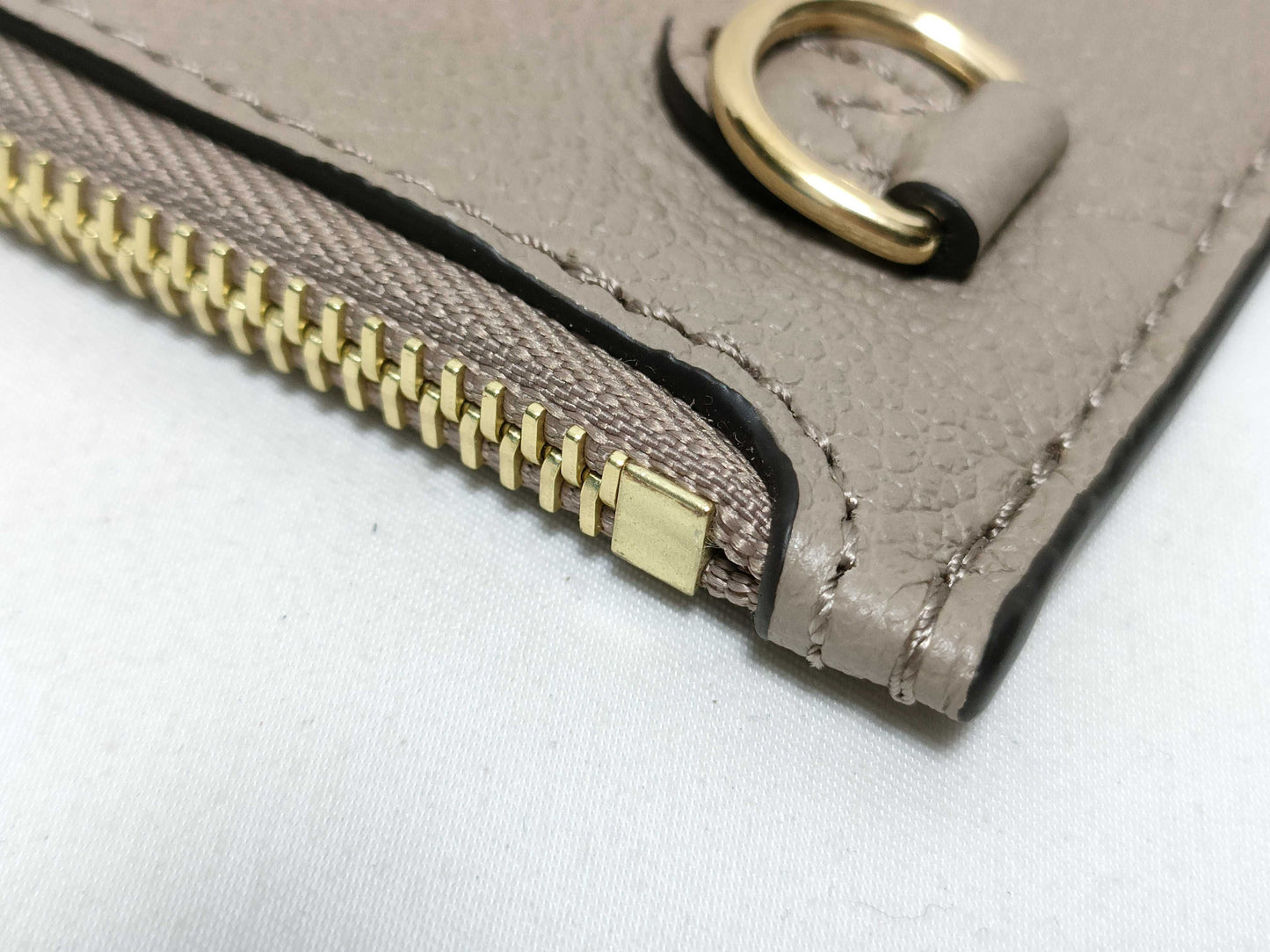 LOUIS VUITTON RFID verification impossible. Serial number verification impossible. Monogram Empreinte Louis Vuitton Neverfull Pouch in Taupe with Gold Hardware.