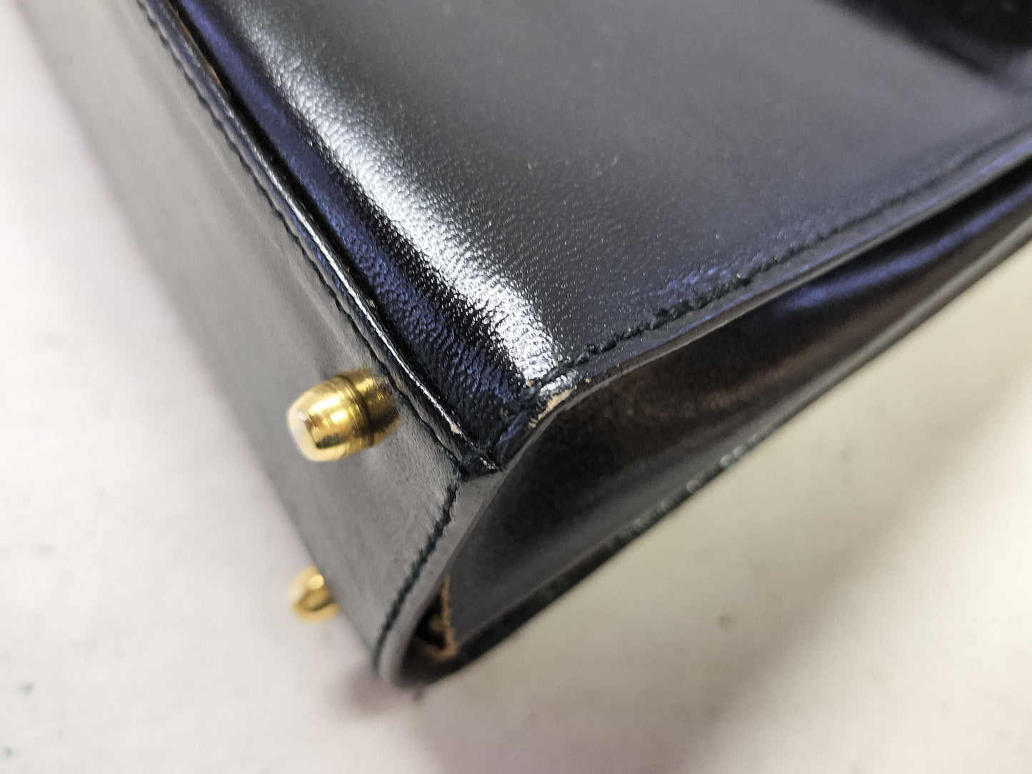 BALLY 2-way Kelly-style shoulder bag with top handle and turnlock. Black leather.