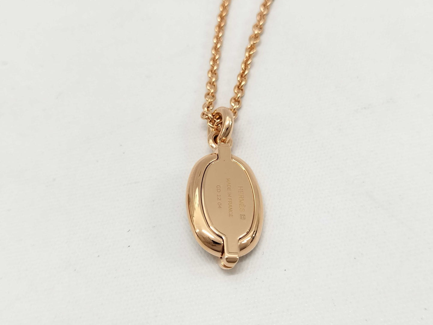 HERMES Mini Maillon pendant in cream with pink gold hardware. Necklace