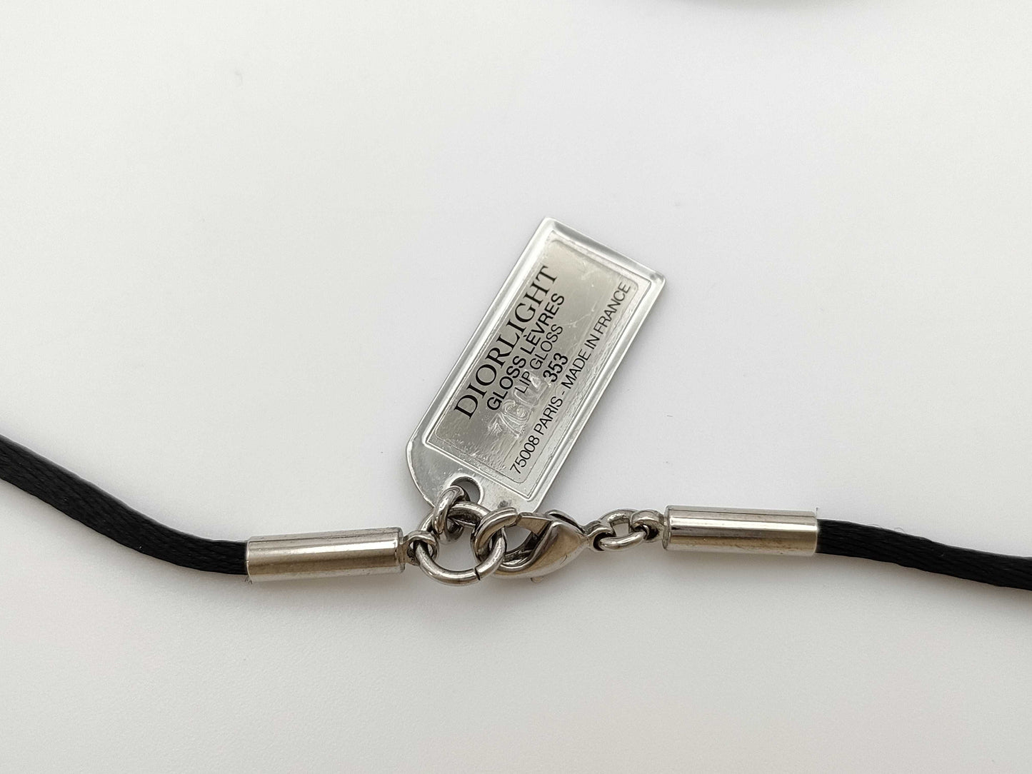 Dior logo mirror ball necklace with rhinestones and lip gloss.