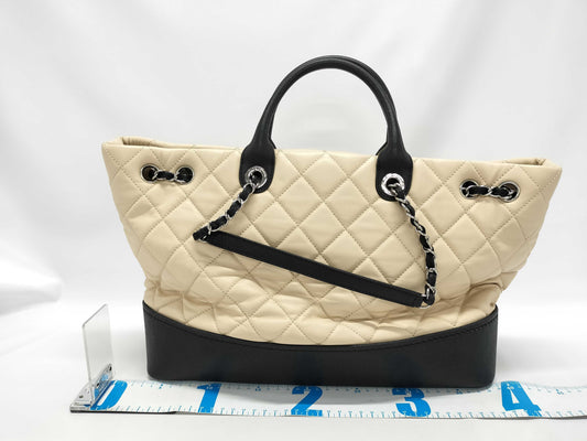 CHANEL Drawstring Shopping Tote, Beige/Black Quilted Lambskin Leather with Silver Hardware