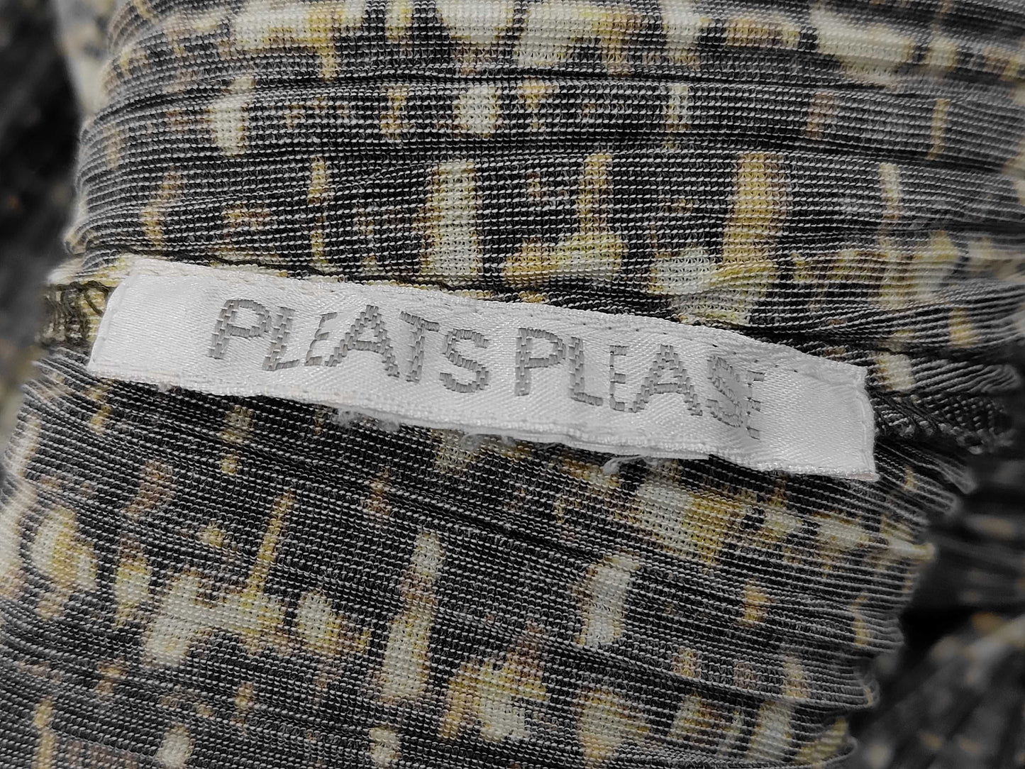 PLEATS PLEASE Issey Miyake long coat with fur collar and shoulder pads, all-over print