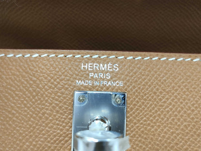 HERMES Kelly 25 handbag with gold exterior, Epsom finish, and silver hardware.