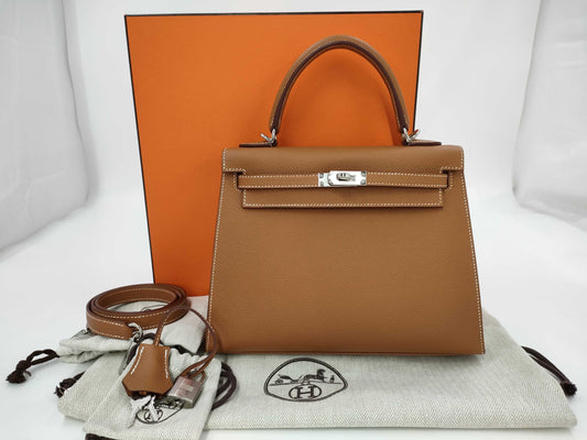 HERMES Kelly 25 handbag with gold exterior, Epsom finish, and silver hardware.