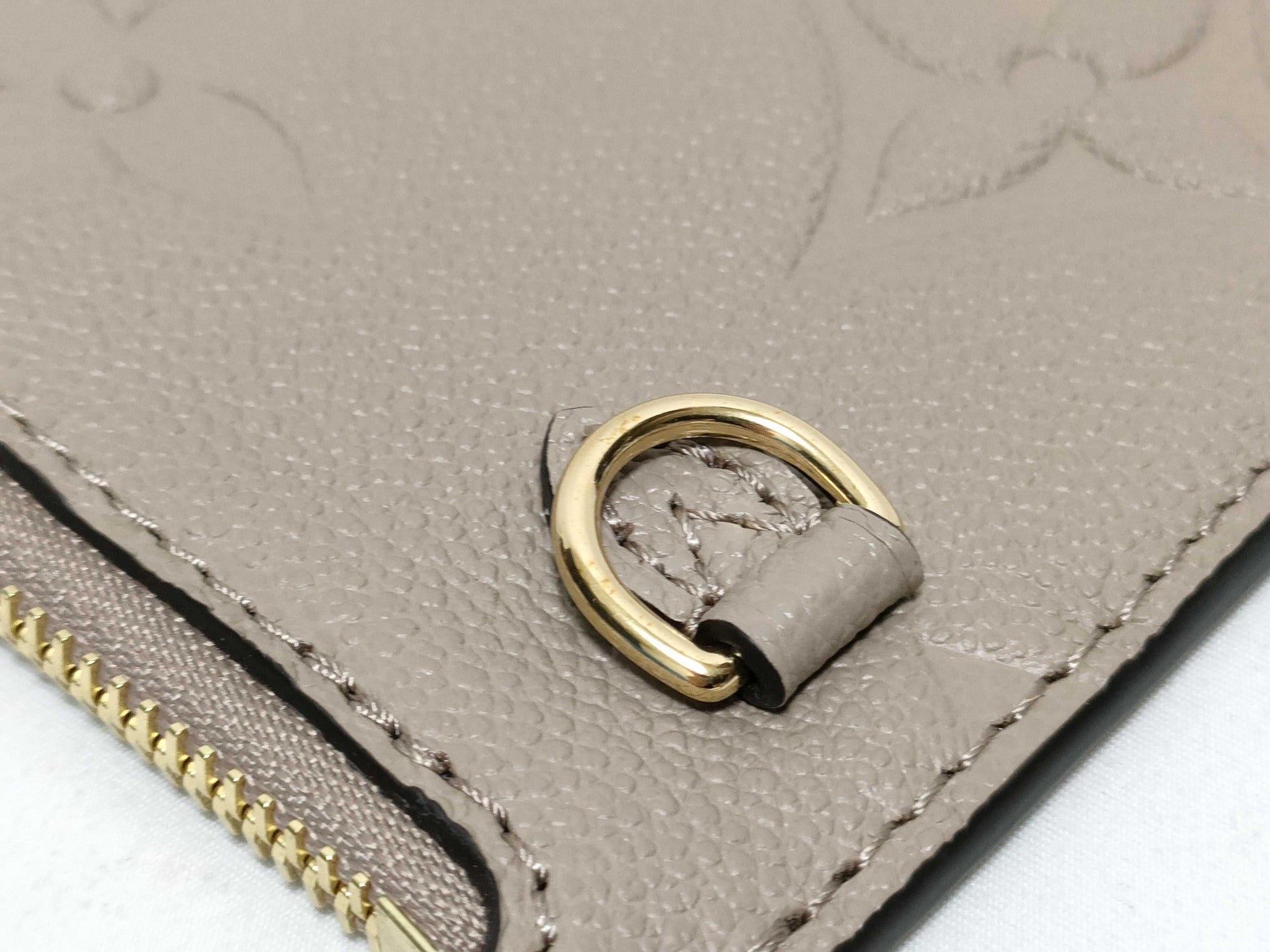 LOUIS VUITTON RFID verification impossible. Serial number verification impossible. Monogram Empreinte Louis Vuitton Neverfull Pouch in Taupe with Gold Hardware.