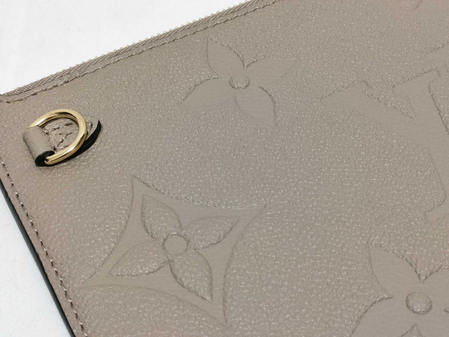 LOUIS VUITTON RFID verification impossible. Serial number verification impossible. Monogram Empreinte Louis Vuitton Neverfull Pouch in Taupe with Gold Hardware.