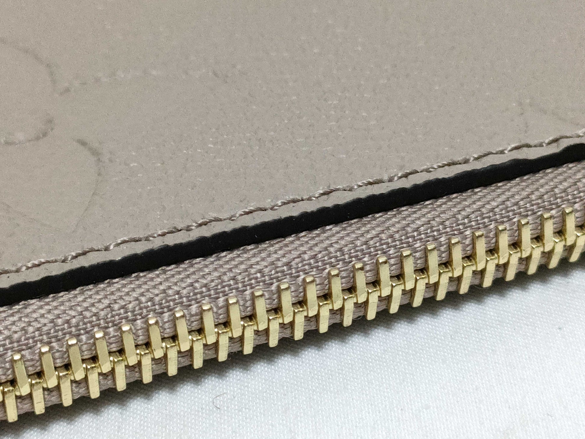 LOUIS VUITTON RFID verification impossible. Serial number verification impossible. Monogram Empreinte Louis Vuitton Neverfull Pouch in Taupe with Gold Hardware.