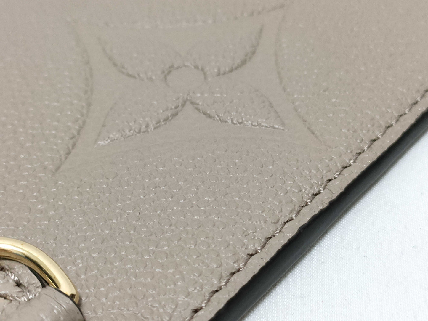 LOUIS VUITTON RFID verification impossible. Serial number verification impossible. Monogram Empreinte Louis Vuitton Neverfull Pouch in Taupe with Gold Hardware.