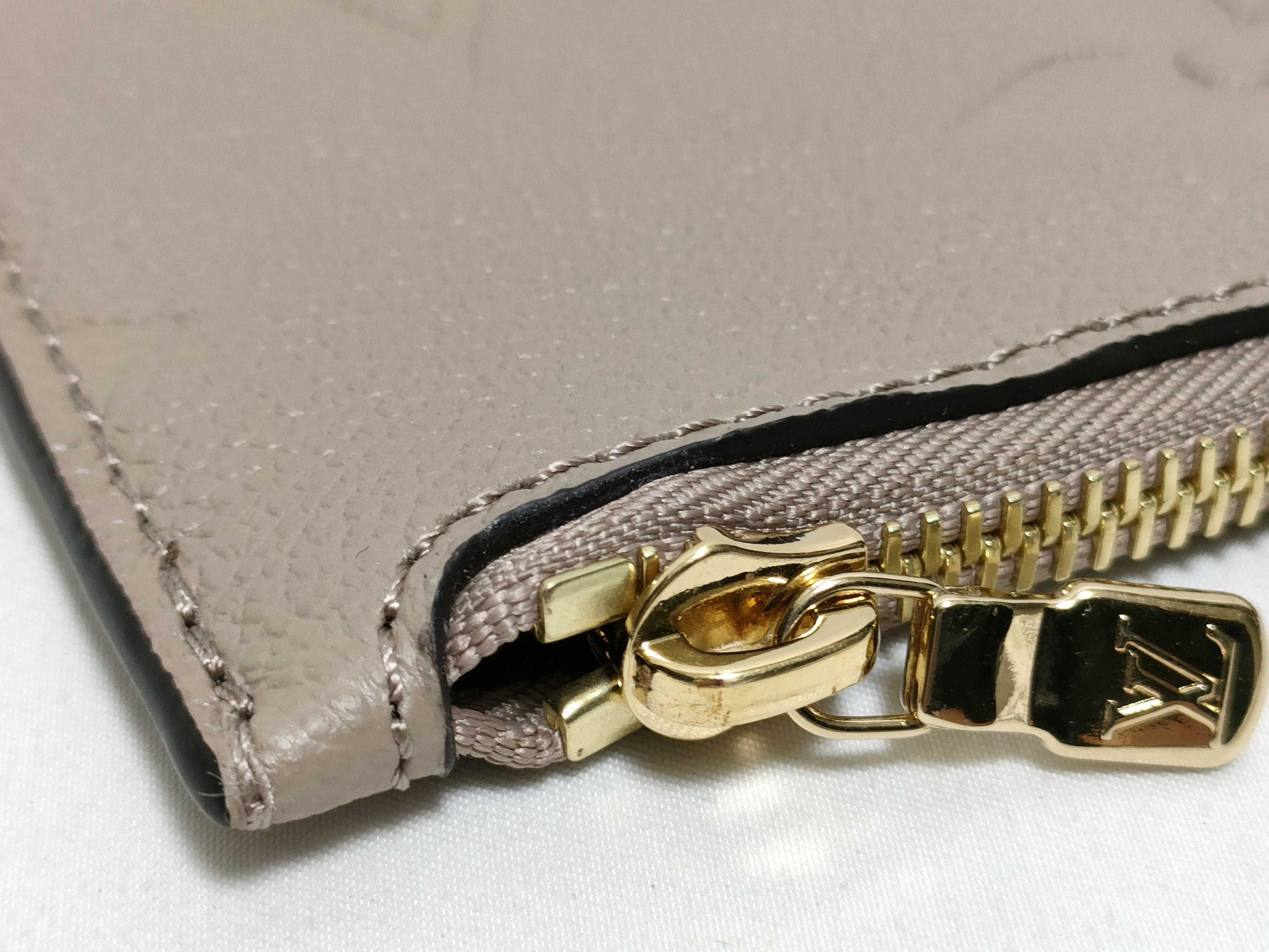 LOUIS VUITTON RFID verification impossible. Serial number verification impossible. Monogram Empreinte Louis Vuitton Neverfull Pouch in Taupe with Gold Hardware.
