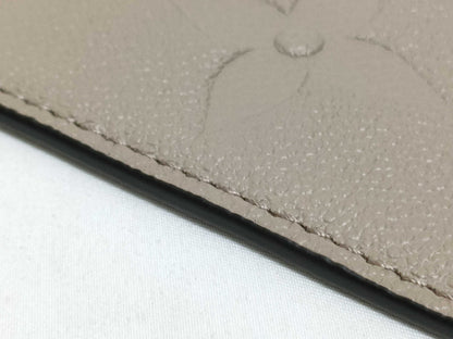LOUIS VUITTON RFID verification impossible. Serial number verification impossible. Monogram Empreinte Louis Vuitton Neverfull Pouch in Taupe with Gold Hardware.