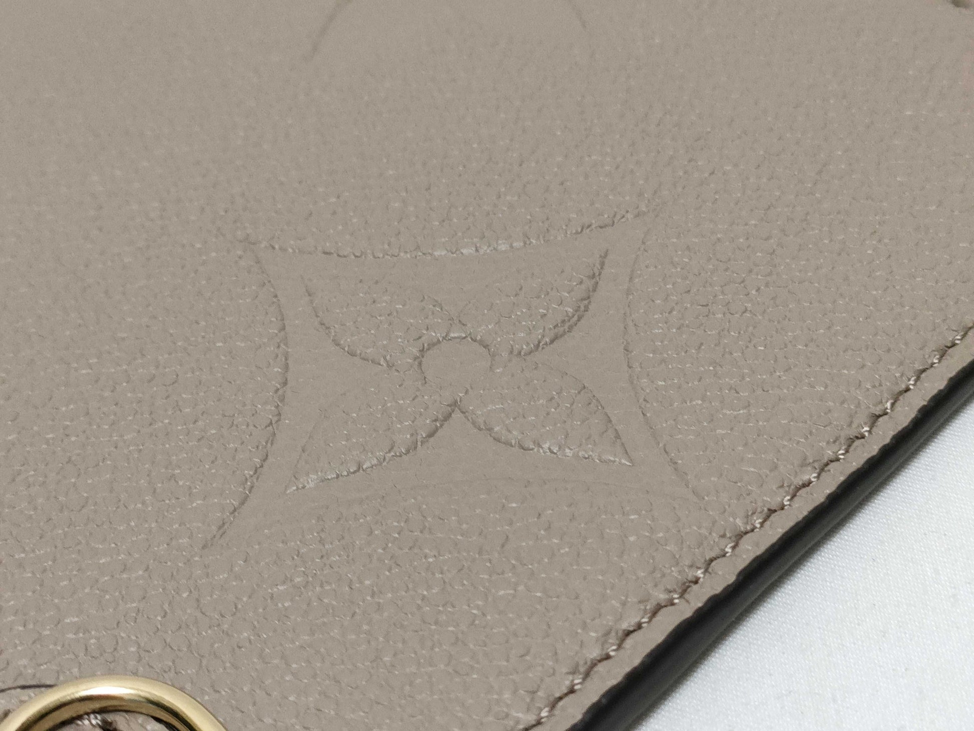LOUIS VUITTON RFID verification impossible. Serial number verification impossible. Monogram Empreinte Louis Vuitton Neverfull Pouch in Taupe with Gold Hardware.
