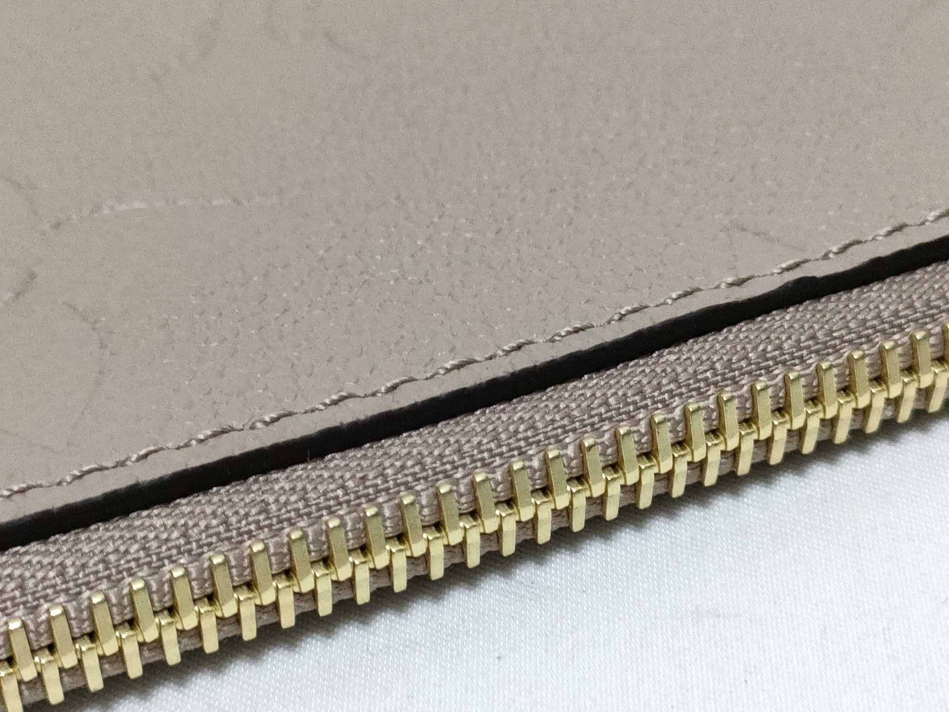 LOUIS VUITTON RFID verification impossible. Serial number verification impossible. Monogram Empreinte Louis Vuitton Neverfull Pouch in Taupe with Gold Hardware.