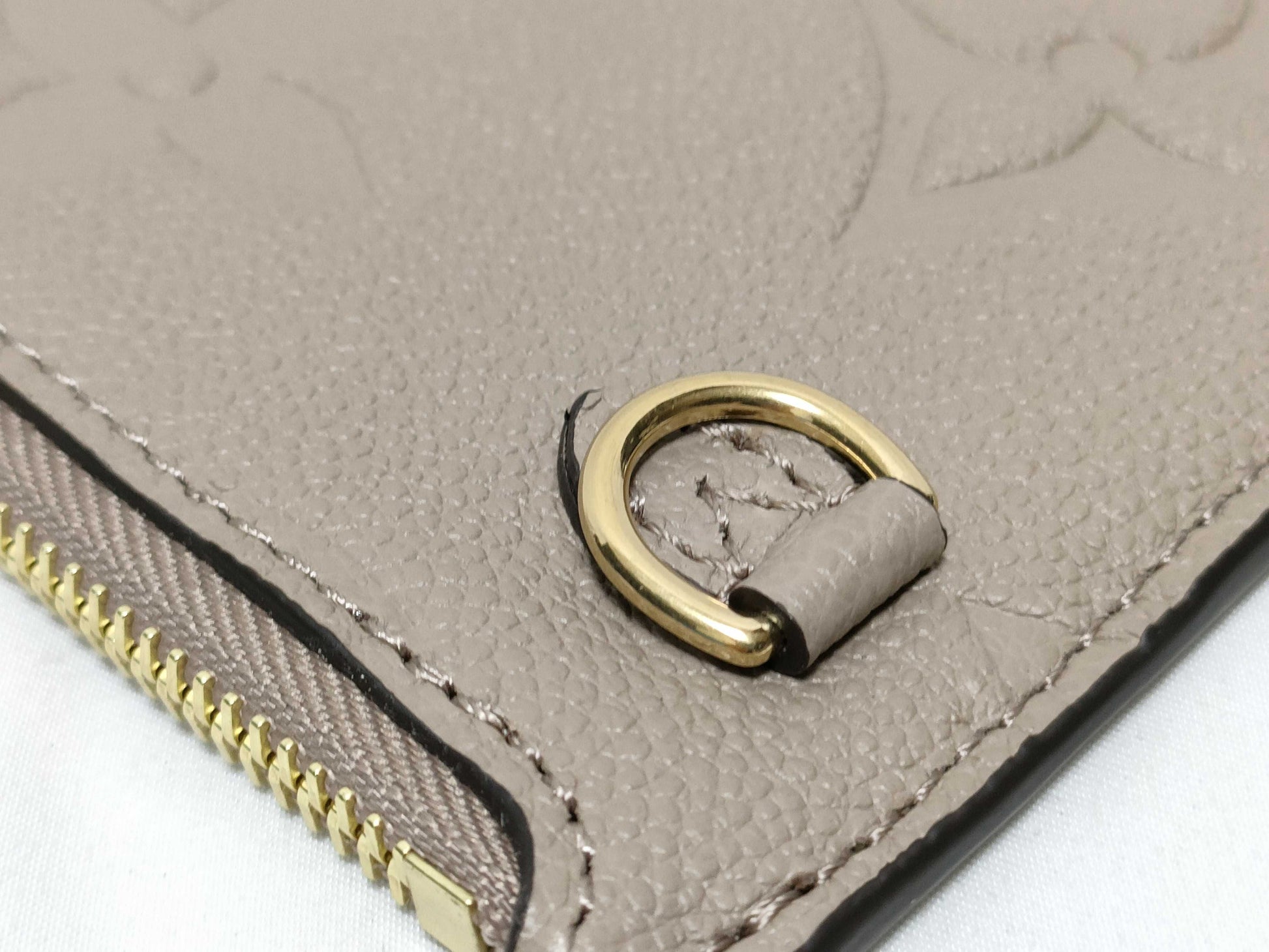 LOUIS VUITTON RFID verification impossible. Serial number verification impossible. Monogram Empreinte Louis Vuitton Neverfull Pouch in Taupe with Gold Hardware.
