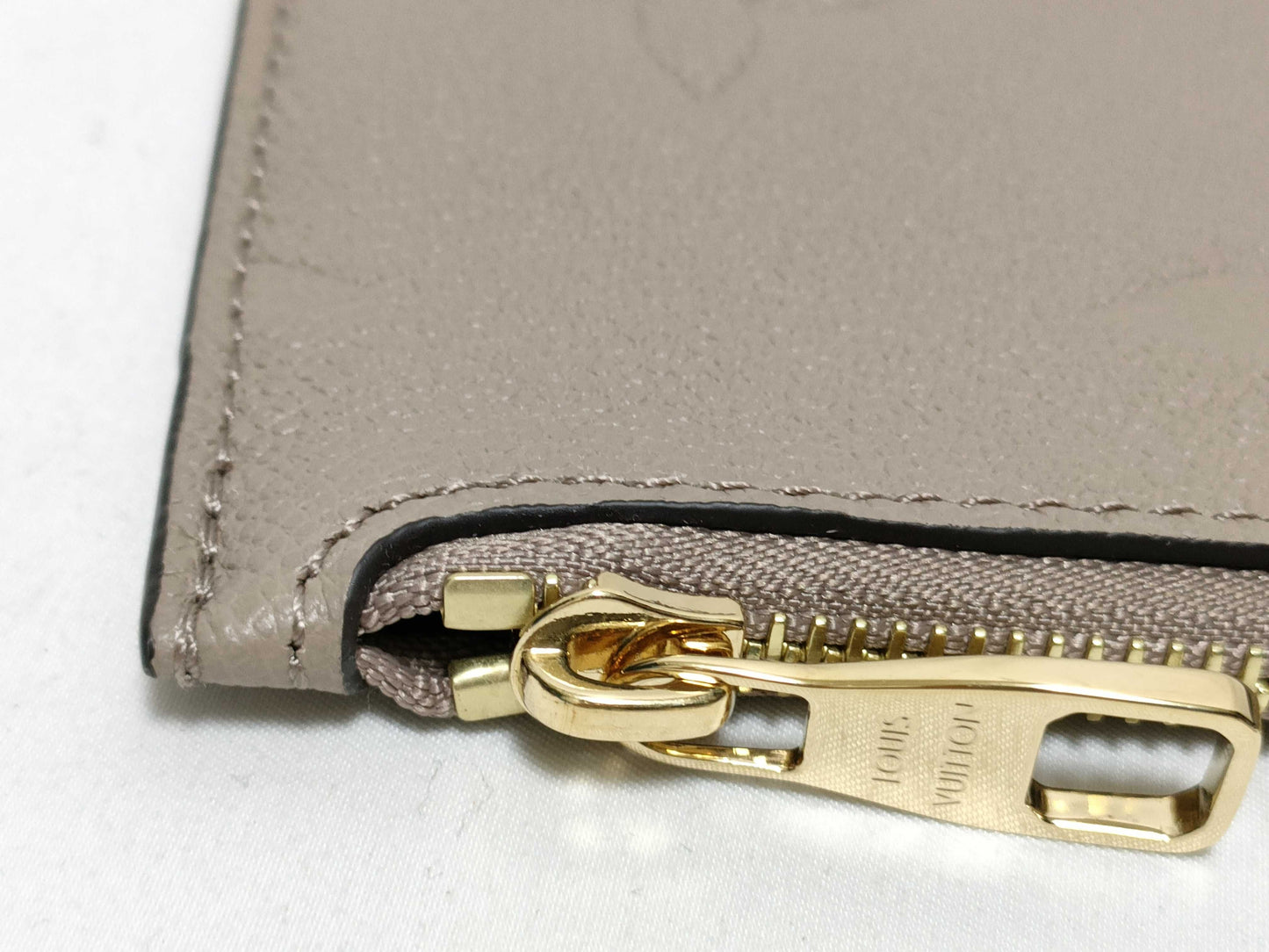 LOUIS VUITTON RFID verification impossible. Serial number verification impossible. Monogram Empreinte Louis Vuitton Neverfull Pouch in Taupe with Gold Hardware.