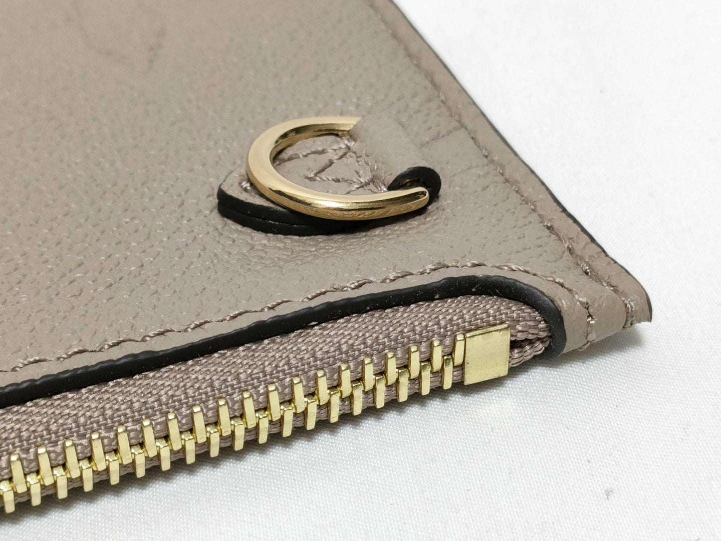 LOUIS VUITTON RFID verification impossible. Serial number verification impossible. Monogram Empreinte Louis Vuitton Neverfull Pouch in Taupe with Gold Hardware.