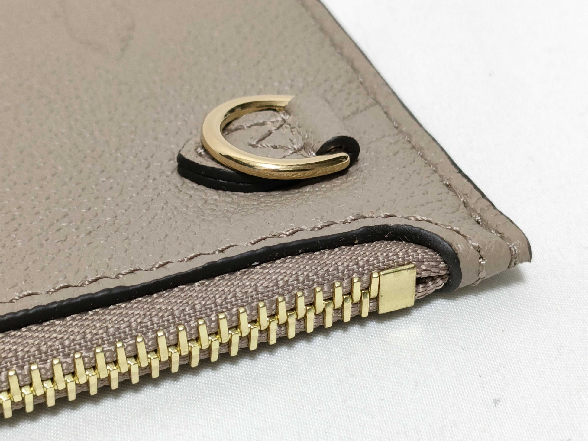 LOUIS VUITTON RFID verification impossible. Serial number verification impossible. Monogram Empreinte Louis Vuitton Neverfull Pouch in Taupe with Gold Hardware.