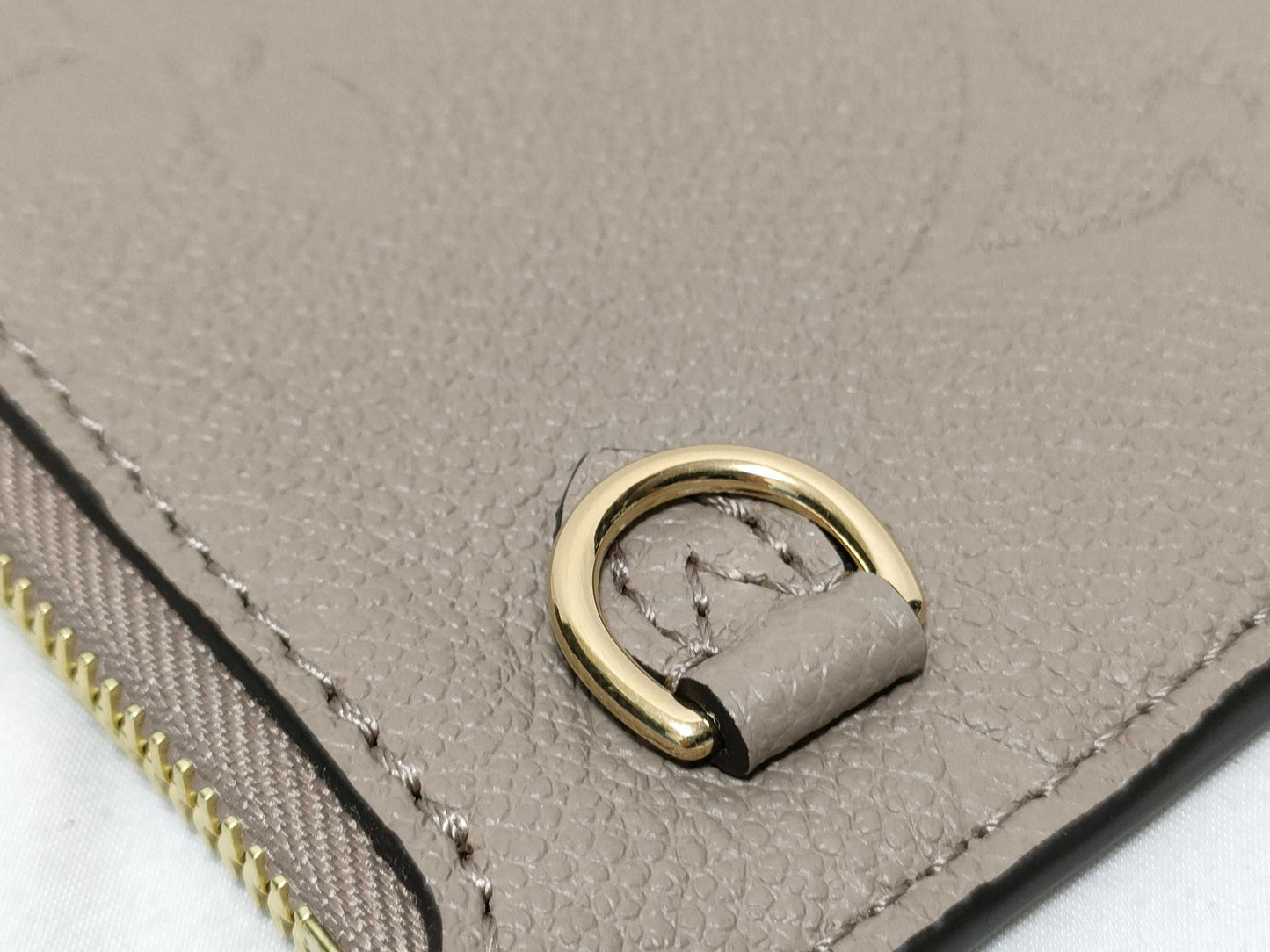 LOUIS VUITTON RFID verification impossible. Serial number verification impossible. Monogram Empreinte Louis Vuitton Neverfull Pouch in Taupe with Gold Hardware.