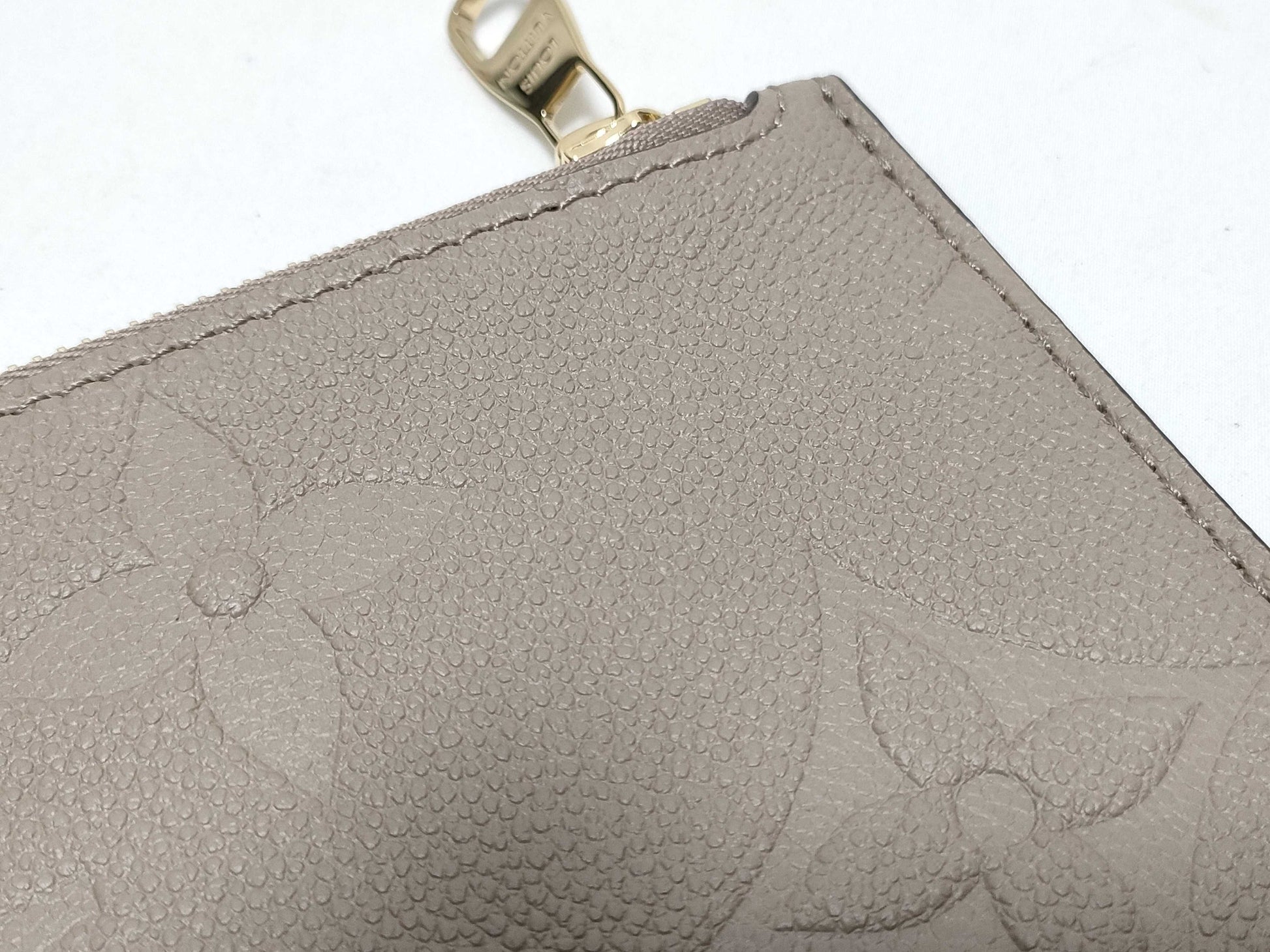 LOUIS VUITTON RFID verification impossible. Serial number verification impossible. Monogram Empreinte Louis Vuitton Neverfull Pouch in Taupe with Gold Hardware.