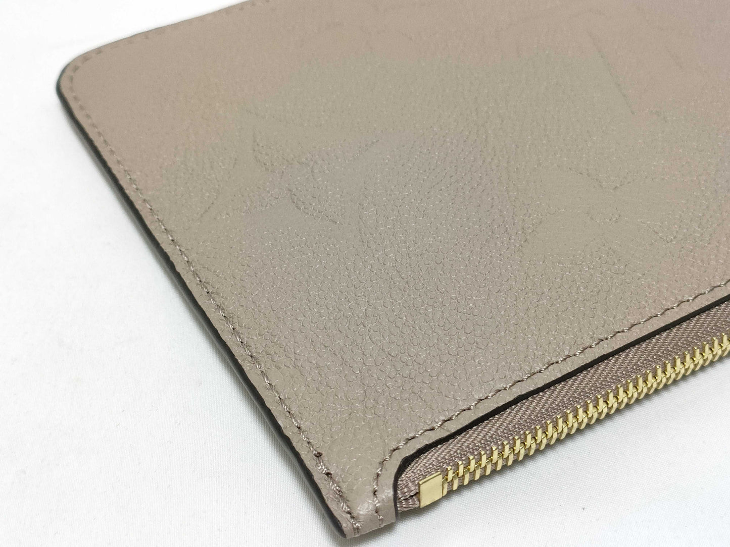 LOUIS VUITTON RFID verification impossible. Serial number verification impossible. Monogram Empreinte Louis Vuitton Neverfull Pouch in Taupe with Gold Hardware.