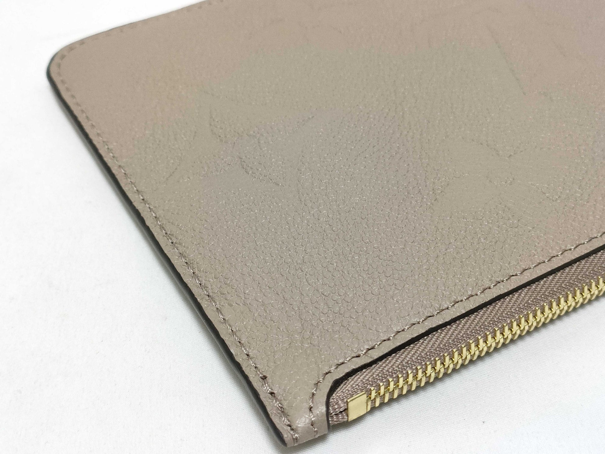 LOUIS VUITTON RFID verification impossible. Serial number verification impossible. Monogram Empreinte Louis Vuitton Neverfull Pouch in Taupe with Gold Hardware.