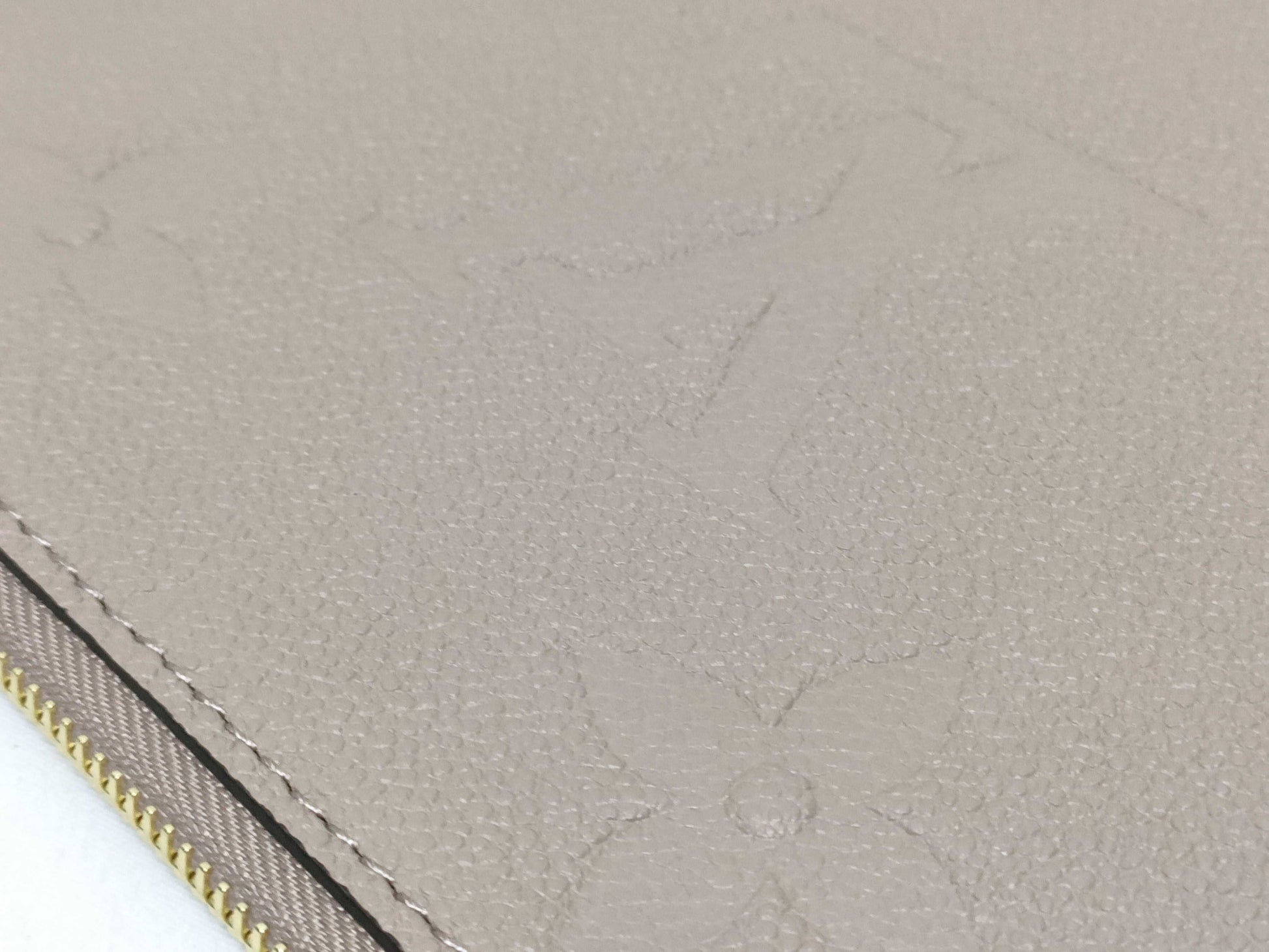 LOUIS VUITTON RFID verification impossible. Serial number verification impossible. Monogram Empreinte Louis Vuitton Neverfull Pouch in Taupe with Gold Hardware.