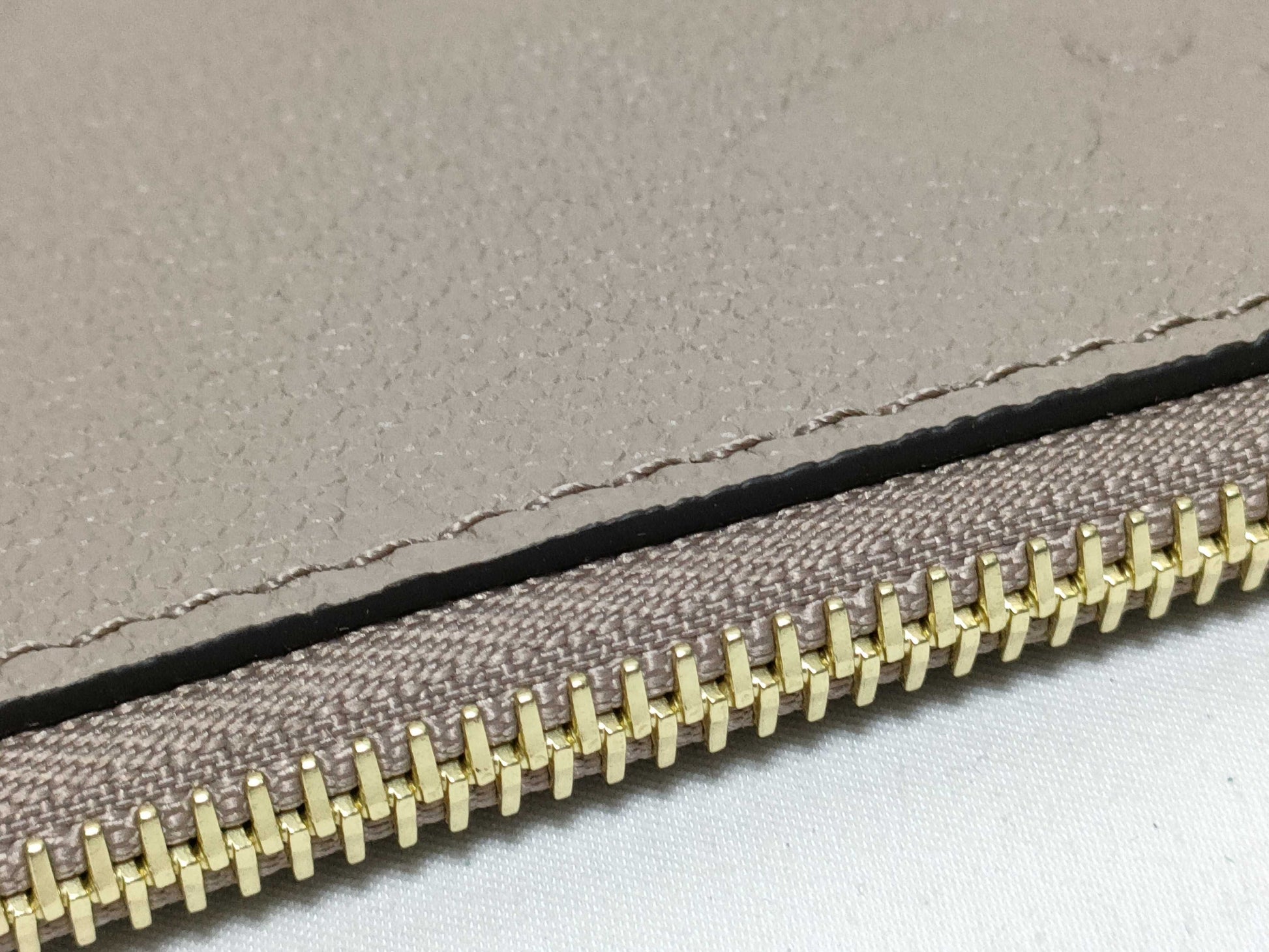 LOUIS VUITTON RFID verification impossible. Serial number verification impossible. Monogram Empreinte Louis Vuitton Neverfull Pouch in Taupe with Gold Hardware.