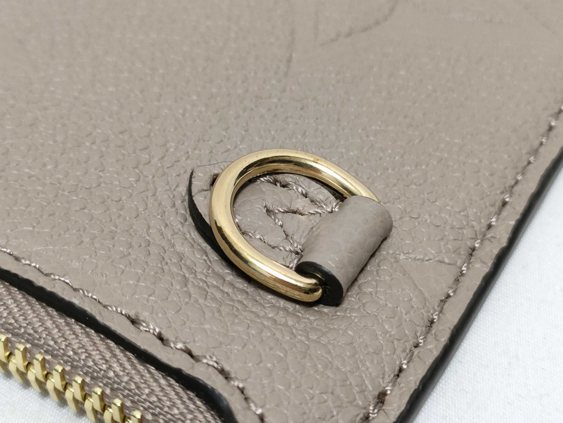 LOUIS VUITTON RFID verification impossible. Serial number verification impossible. Monogram Empreinte Louis Vuitton Neverfull Pouch in Taupe with Gold Hardware.