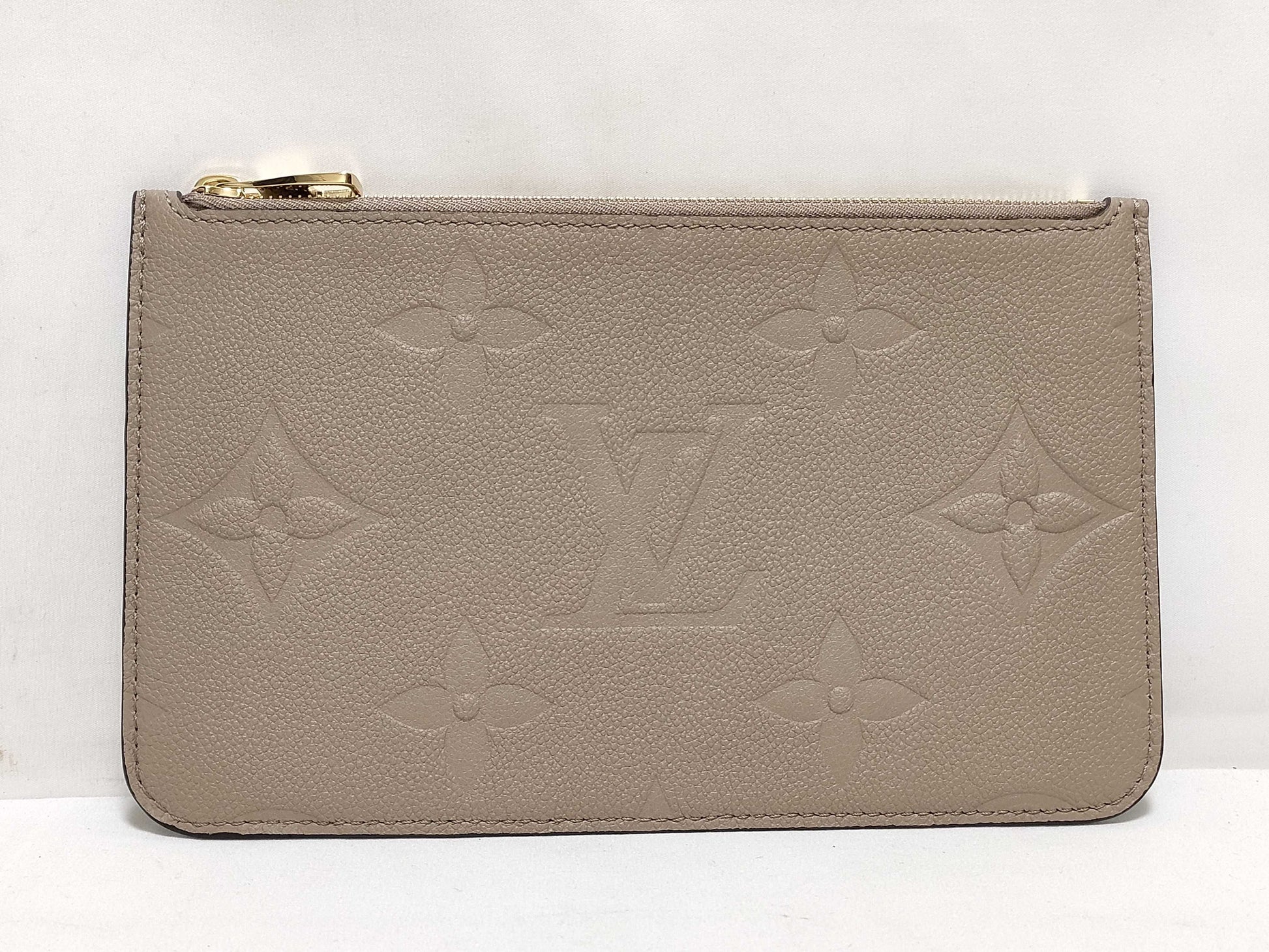LOUIS VUITTON RFID verification impossible. Serial number verification impossible. Monogram Empreinte Louis Vuitton Neverfull Pouch in Taupe with Gold Hardware.
