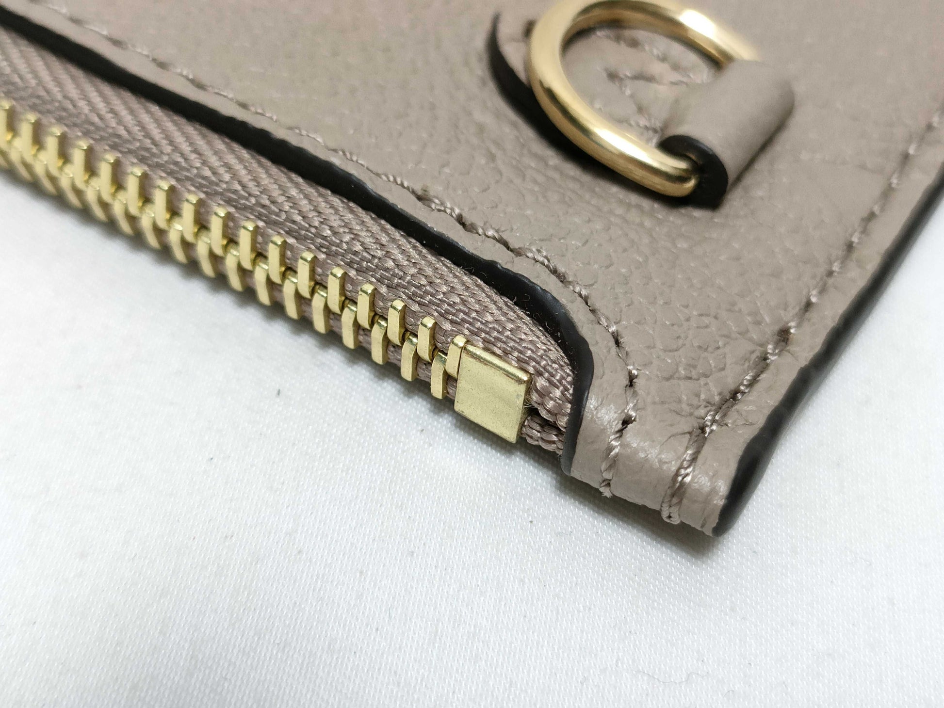 LOUIS VUITTON RFID verification impossible. Serial number verification impossible. Monogram Empreinte Louis Vuitton Neverfull Pouch in Taupe with Gold Hardware.