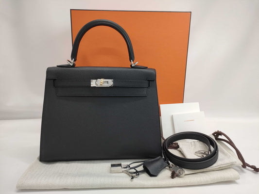 Brand new Hermès Kelly 25 shoulder bag in black with Epsom leather, electrum hardware, exterior stitching, K stamp, and protective seal.