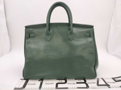 Green handbag with padlock, key and clochette