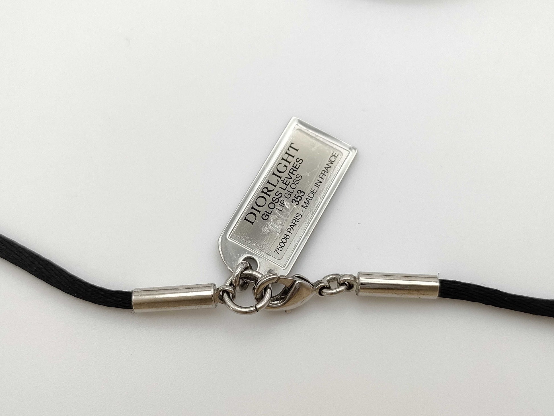 Dior logo mirror ball necklace with rhinestones and lip gloss.