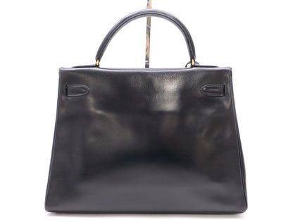 HERMES Box Calf Kelly 32 Black with GD hardware, padlock, two keys, cloche, dust bag, and box. 〇N stamped. 1984.