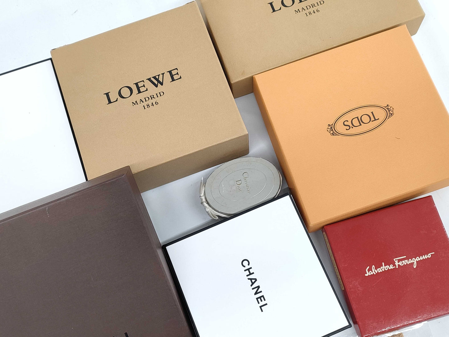 Empty Louis Vuitton, Gucci, Chanel, Loewe, and other brand-name boxes and dust bags. One M-tiered box. Empty brand-name boxes.